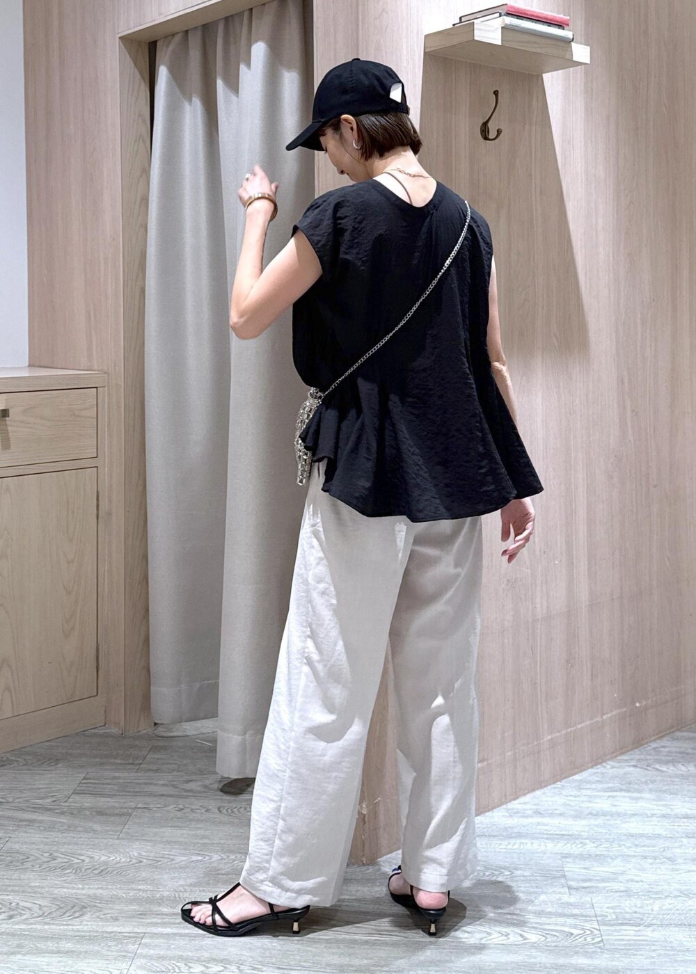 ブラック系のサンダル、ブラック系のシャツ/ブラウス、ホワイト系のスラックスを着用したレディースの夏コーディネートの4枚目の写真