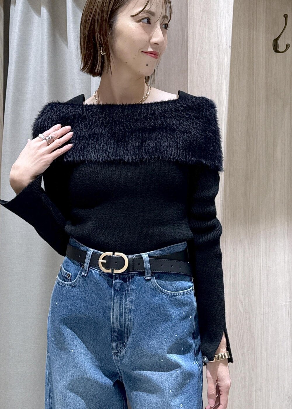 ブルー系のデニムパンツ、イエロー系のハンドバッグ、ブラック系のニット/セーターを着用したレディースの冬コーディネートの7枚目の写真