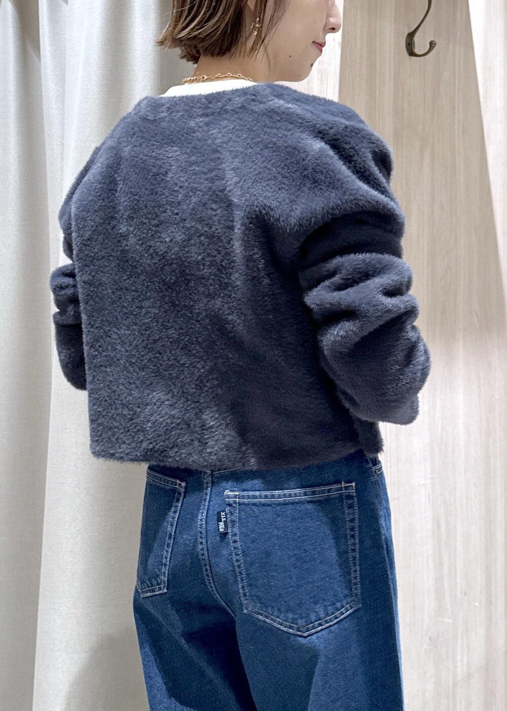 グレー系のショルダーバッグ、グレー系のデニムパンツ、ブルー系のカーディガン/ボレロを着用したレディースの秋コーディネートの9枚目の写真