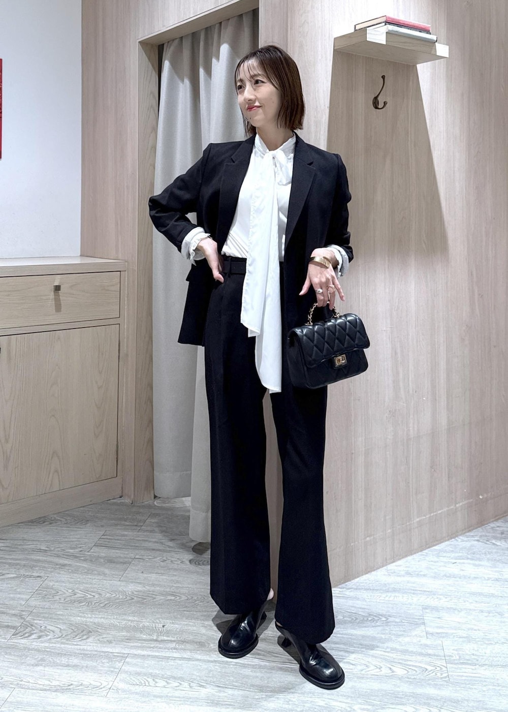 ブラック系のスラックス、ブラック系のテーラードジャケット、グレー系のその他アウターを着用したレディースの冬コーディネートの9枚目の写真
