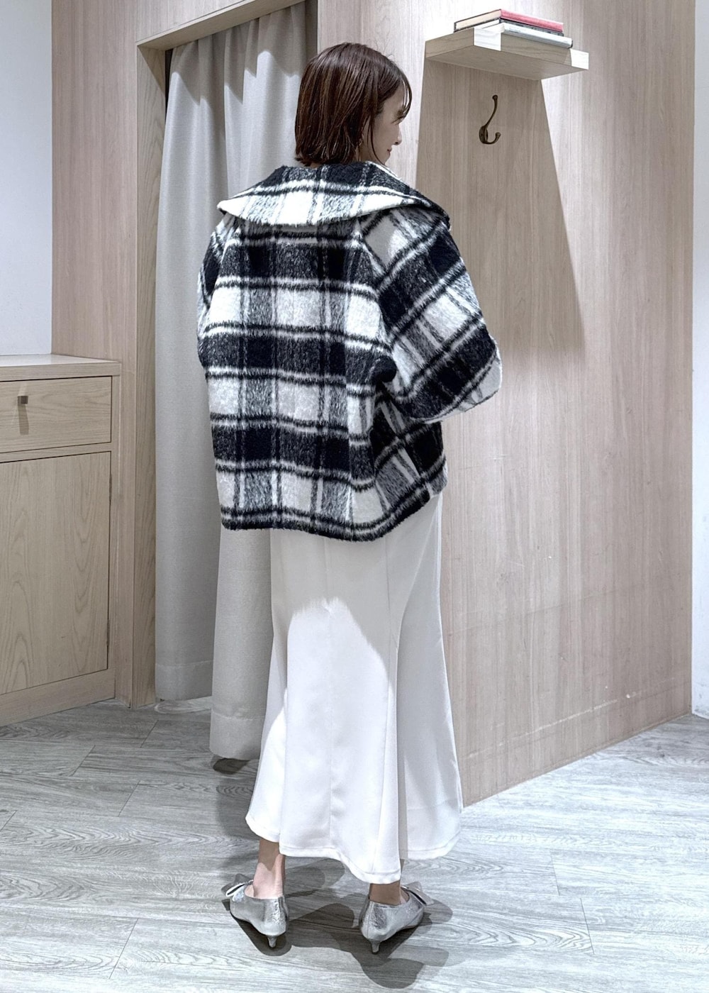 シルバー系のパンプス、ホワイト系のハンドバッグ、ブルー系のニット/セーターを着用したレディースの秋コーディネートの7枚目の写真