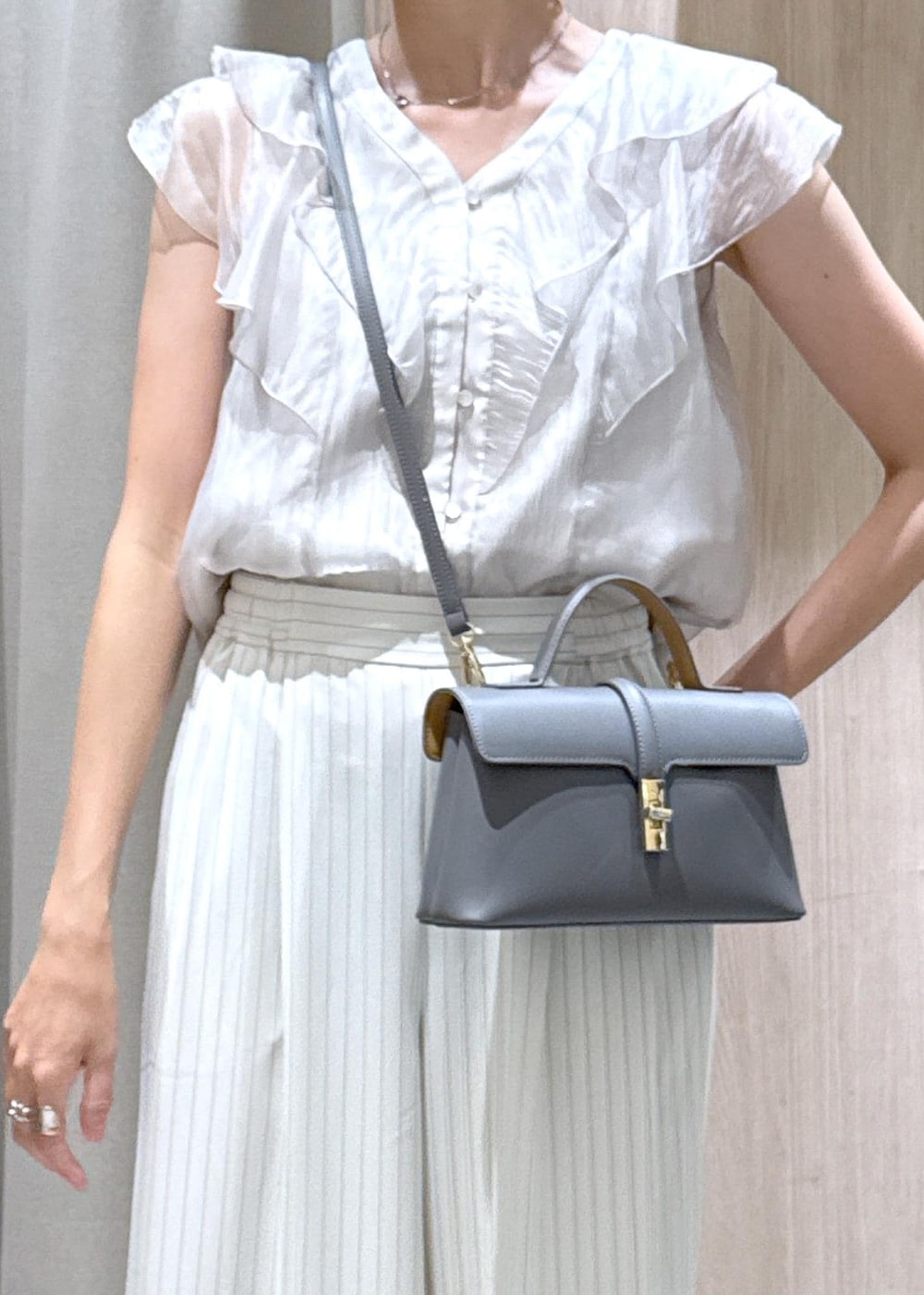 グレー系のショルダーバッグ、シルバー系のパンプス、ベージュ系のシャツ/ブラウスを着用したレディースの夏コーディネートの8枚目の写真