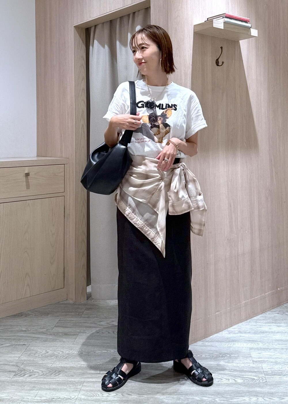 グレー系のスカート、ベージュ系のシャツ/ブラウス、ホワイト系のTシャツ/カットソーを着用したレディースの夏コーディネートの3枚目の写真