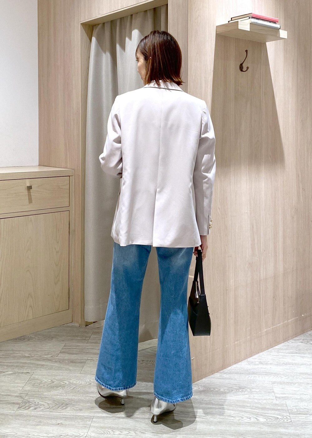 ブラック系のハンドバッグ、ホワイト系のニット/セーター、ベージュ系のテーラードジャケットを着用したレディースの冬コーディネートの7枚目の写真