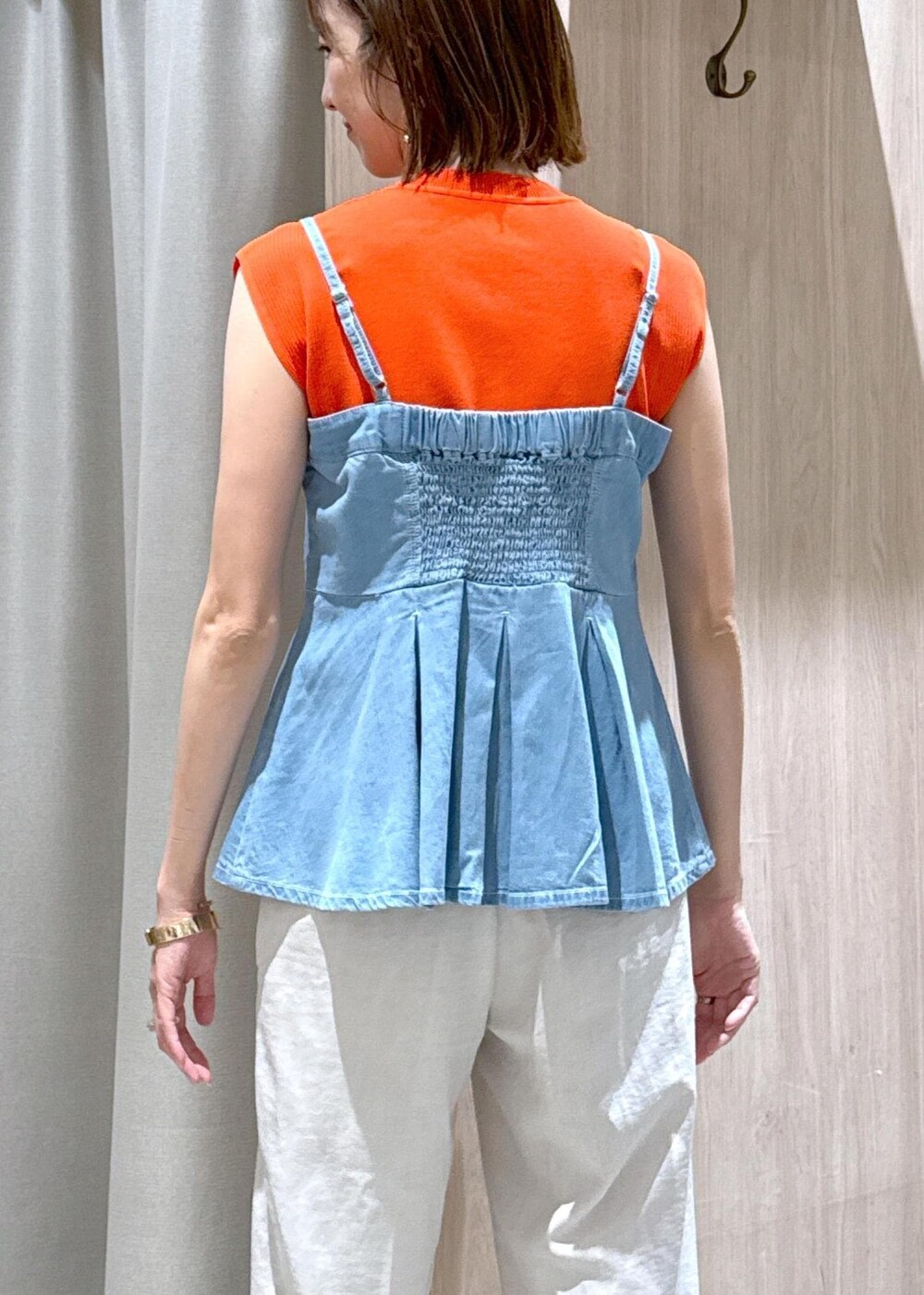 シルバー系のパンプス、ブルー系のキャミソール、オレンジ系のニット/セーターを着用したレディースの夏コーディネートの8枚目の写真