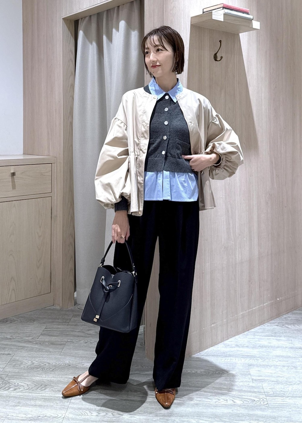 ブラック系のショルダーバッグ、イエロー系のパンプス、ベージュ系のブルゾンを着用したレディースの秋コーディネートの5枚目の写真