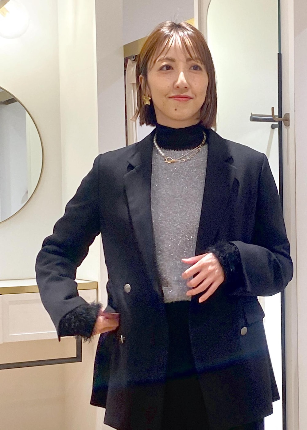 ブラック系のニット/セーター、ブラック系のスラックス、ブラック系のテーラードジャケットを着用したレディースの冬コーディネートの8枚目の写真