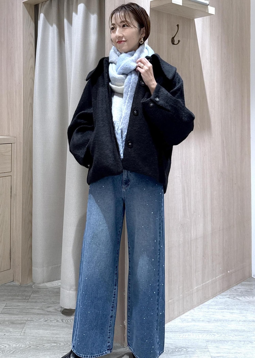 グレー系のカーディガン/ボレロ、ブラック系のブルゾン、ブルー系のデニムパンツを着用したレディースの秋コーディネートの7枚目の写真