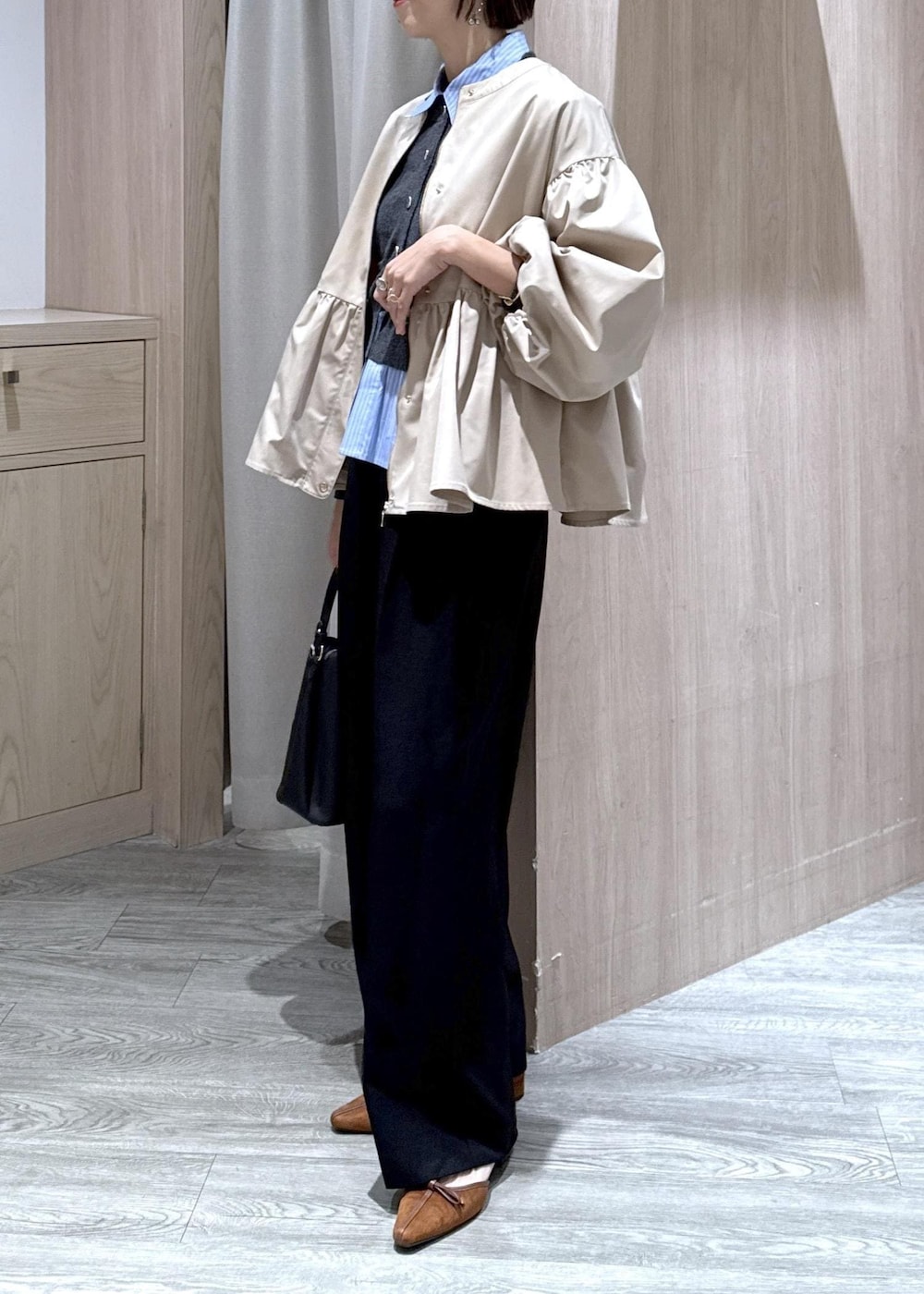 ブラック系のショルダーバッグ、イエロー系のパンプス、ベージュ系のブルゾンを着用したレディースの秋コーディネートの2枚目の写真