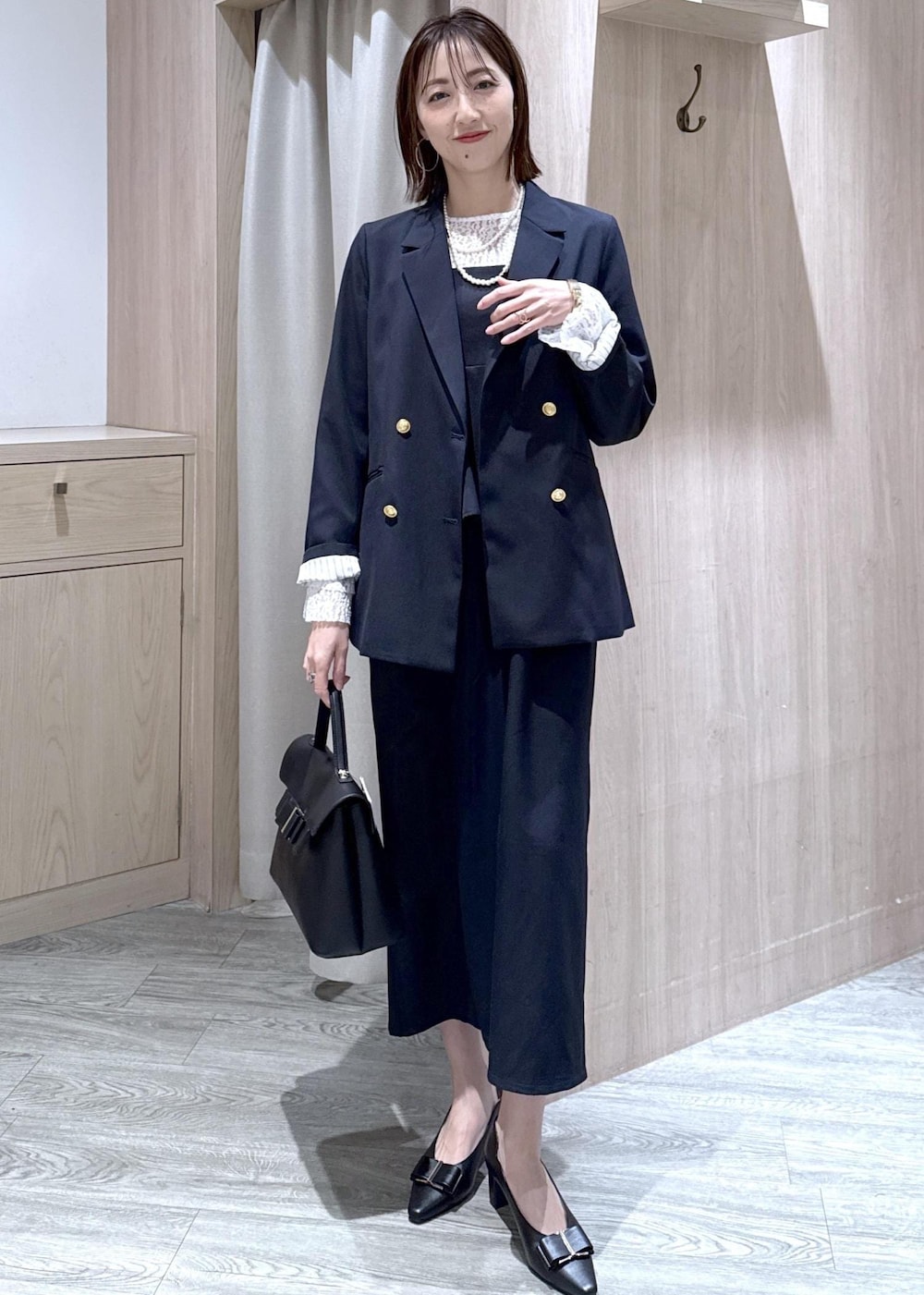 ブラック系のパンプス、ブルー系のテーラードジャケット、ブルー系のワンピースを着用したレディースの冬コーディネートの10枚目の写真