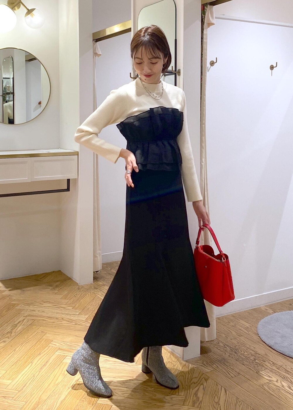 シルバー系のブーツ、ブラック系のスカート、ホワイト系のニット/セーターを着用したレディースの冬コーディネートの5枚目の写真