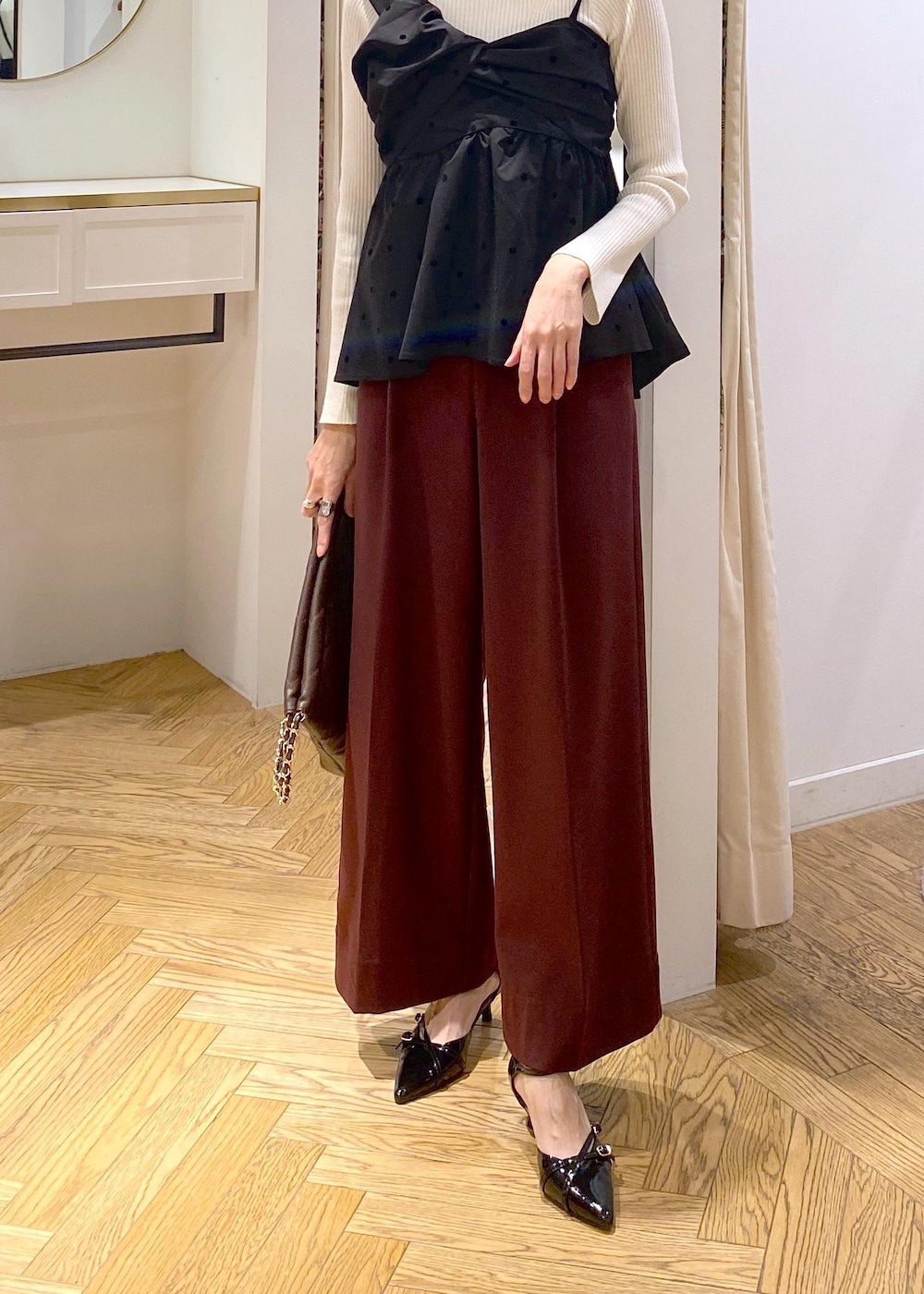 ブラック系のパンプス、ブラック系のキャミソール、ホワイト系のニット/セーターを着用したレディースの冬コーディネートの5枚目の写真