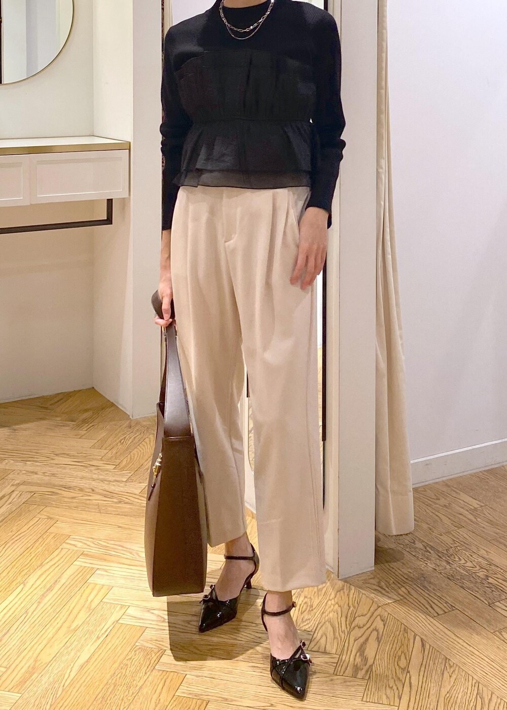 ブラック系のパンプス、ブラック系のニット/セーター、ベージュ系のその他パンツを着用したレディースの冬コーディネートの4枚目の写真