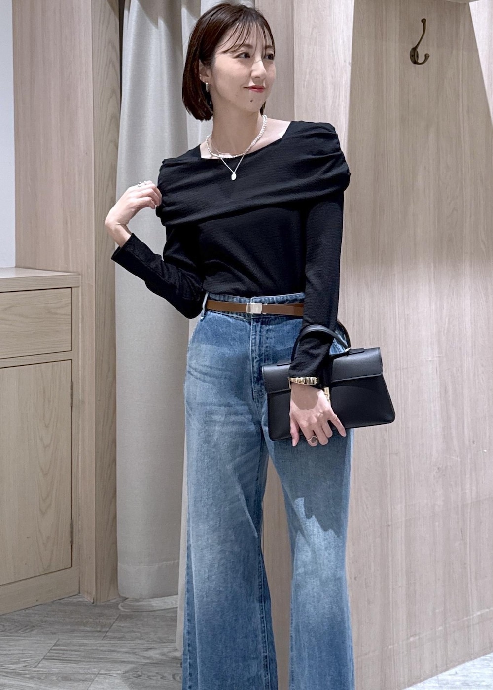 ブラック系のショルダーバッグ、ブルー系のデニムパンツ、ブラック系のTシャツ/カットソーを着用したレディースの春コーディネートの2枚目の写真