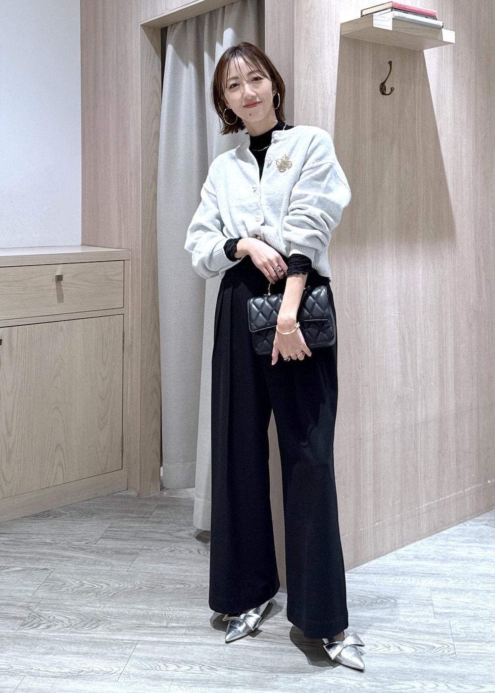 シルバー系のパンプス、グレー系のカーディガン/ボレロ、ブラック系のTシャツ/カットソーを着用したレディースの冬コーディネートの10枚目の写真