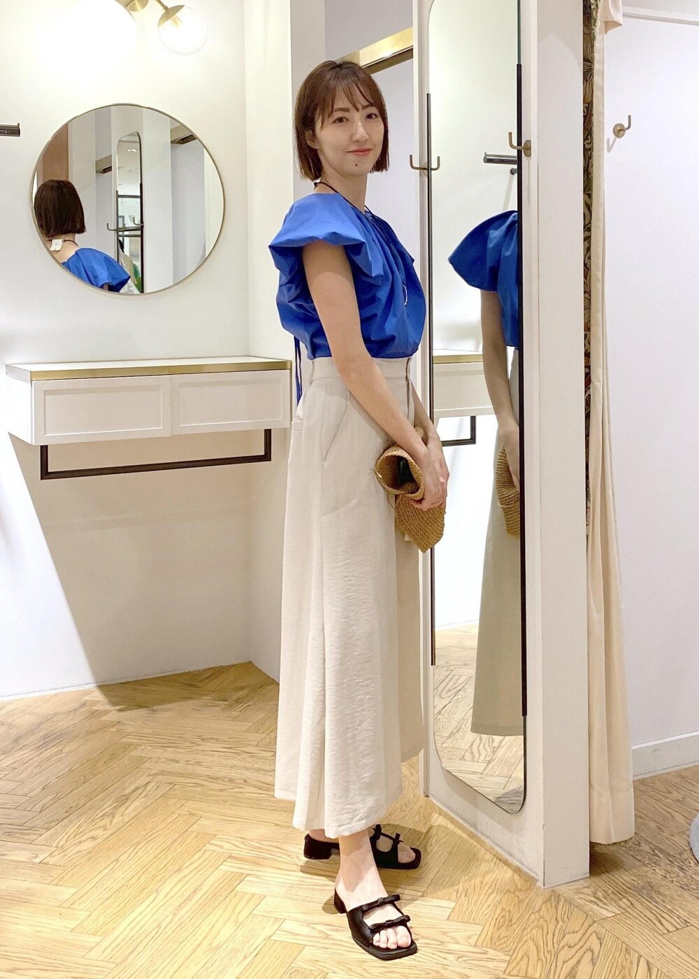 ブラック系のキャミソール、ブラック系のサンダル、ホワイト系のスカートを着用したレディースの春コーディネートの2枚目の写真