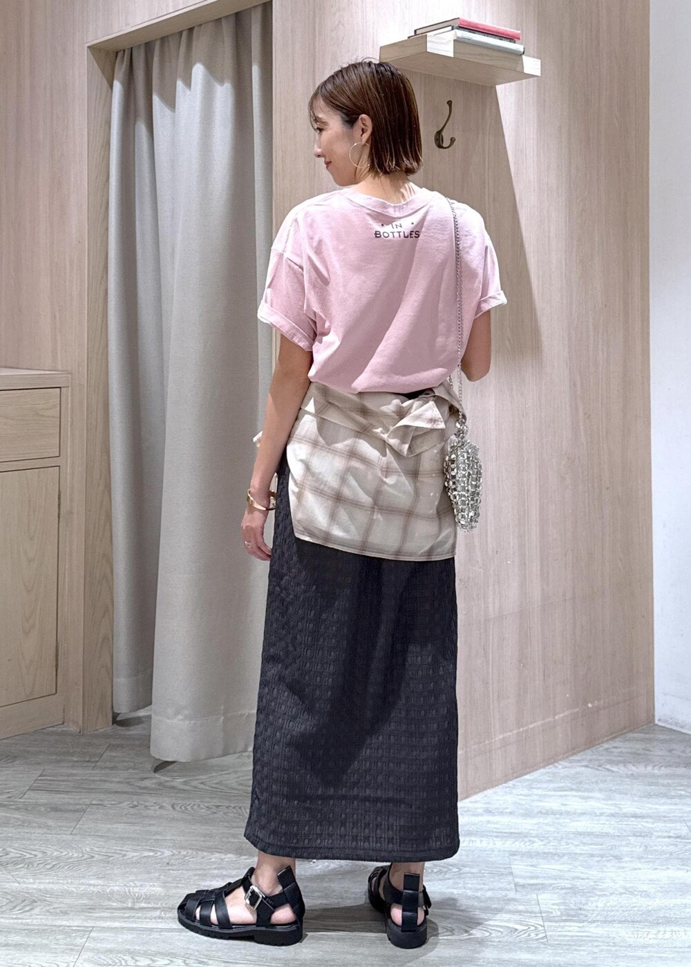 シルバー系のハンドバッグ、ベージュ系のシャツ/ブラウス、グレー系のスカートを着用したレディースの夏コーディネートの3枚目の写真