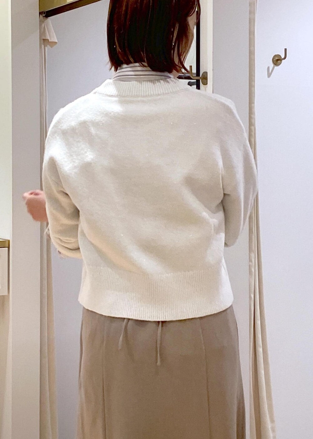 ブラック系のパンプス、ベージュ系のスカート、ホワイト系のシャツ/ブラウスを着用したレディースの冬コーディネートの8枚目の写真