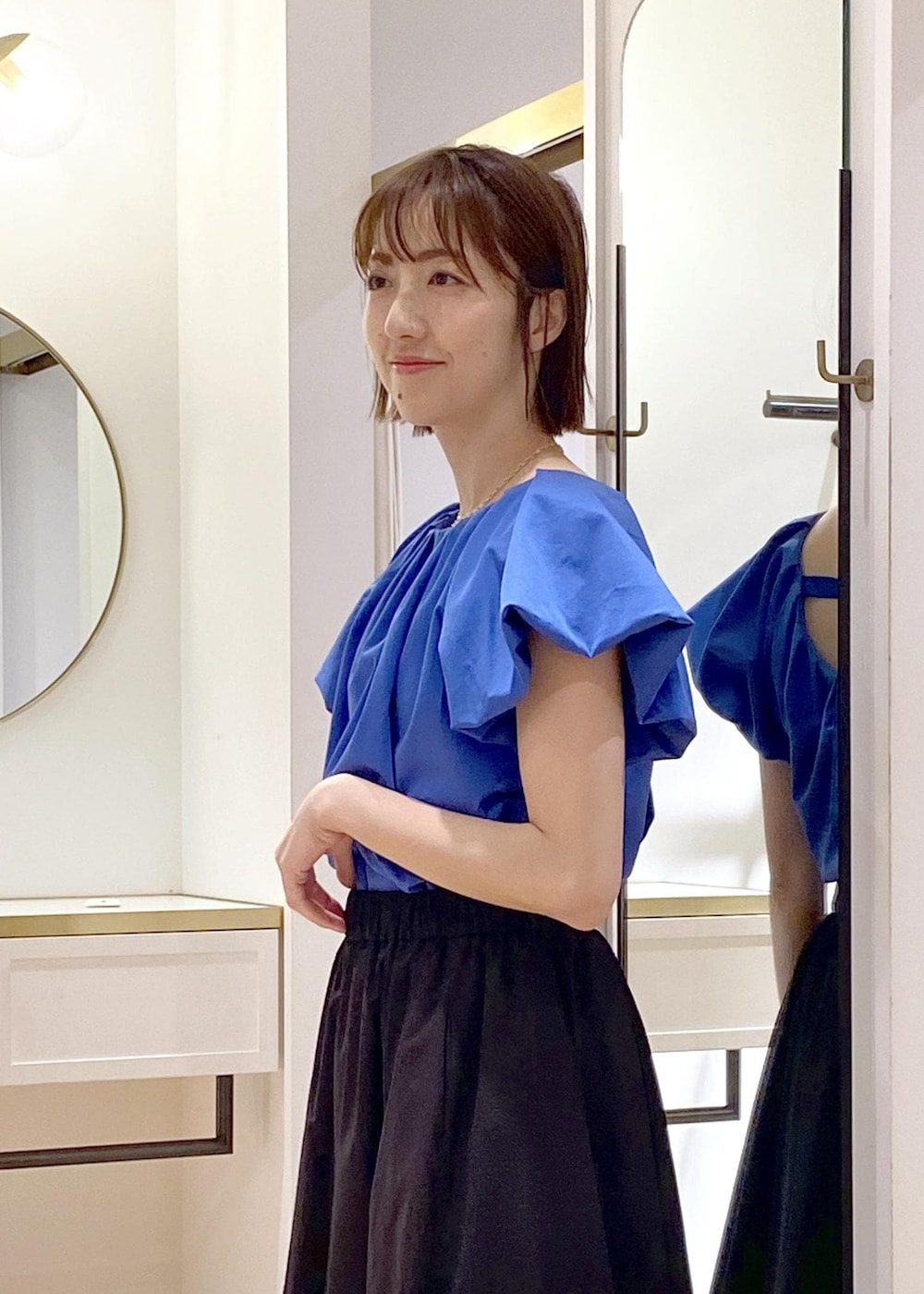 ブラック系のキャミソール、ホワイト系のサンダル、ブラック系のスカートを着用したレディースの春コーディネートの3枚目の写真