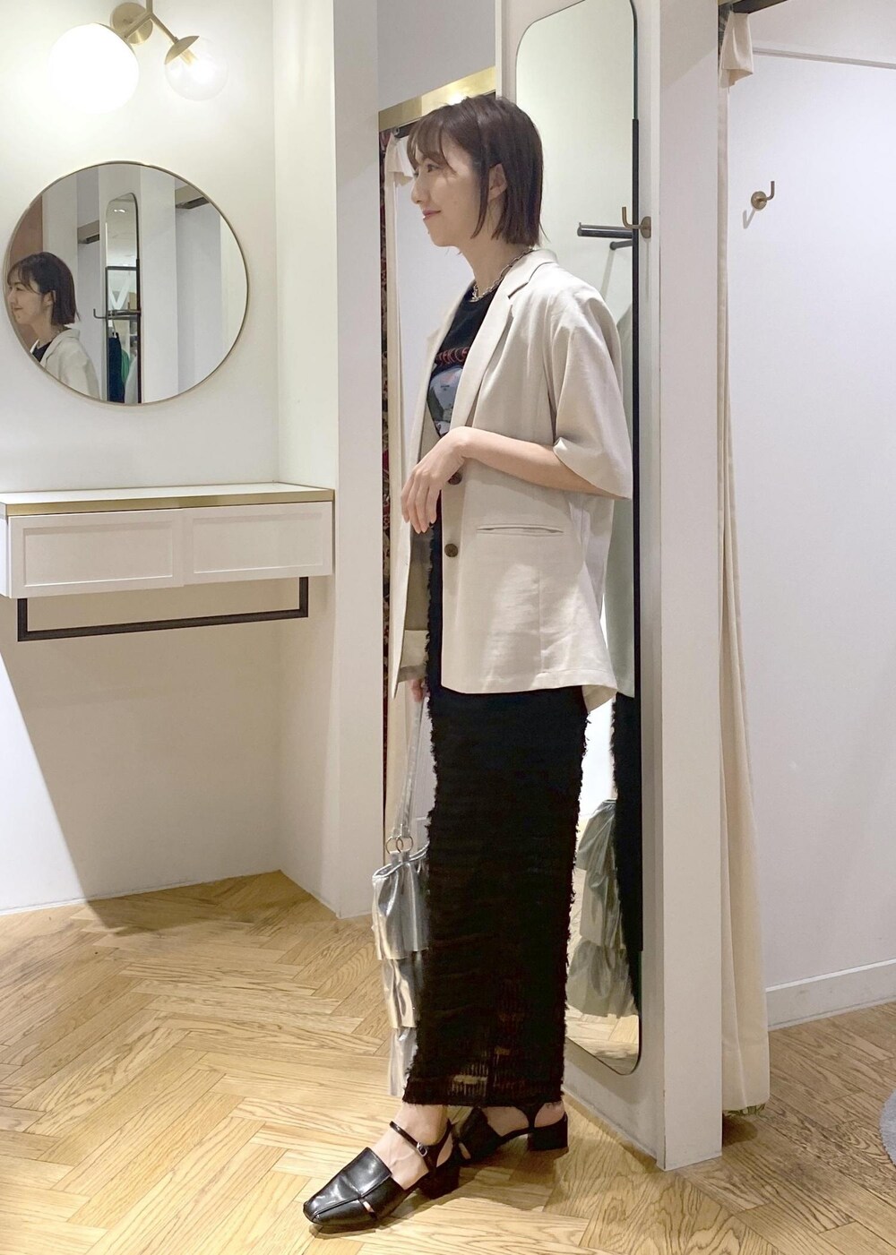 ブラック系のサンダル、ブラック系のTシャツ/カットソー、シルバー系のトートバッグを着用したレディースの夏コーディネートの2枚目の写真