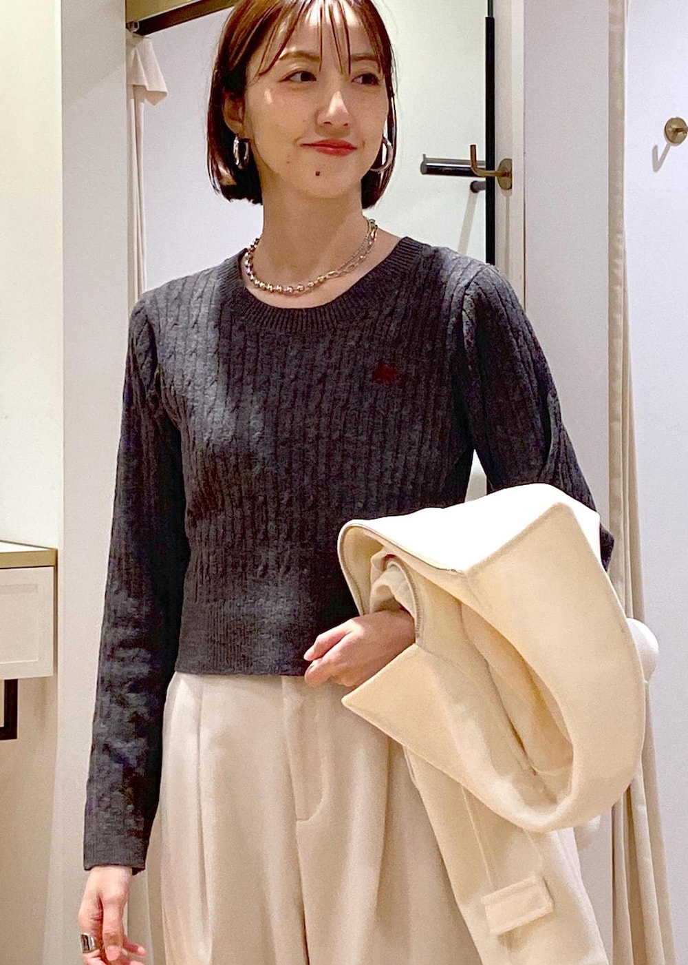 ブルー系のハンドバッグ、ホワイト系のブルゾン、ブラック系のパンプスを着用したレディースの冬コーディネートの9枚目の写真