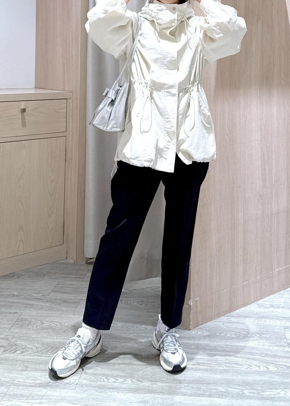 シルバー系のショルダーバッグ、ブラック系のその他パンツ、ホワイト系のマウンテンパーカーを着用したレディースの冬コーディネートの5枚目の写真