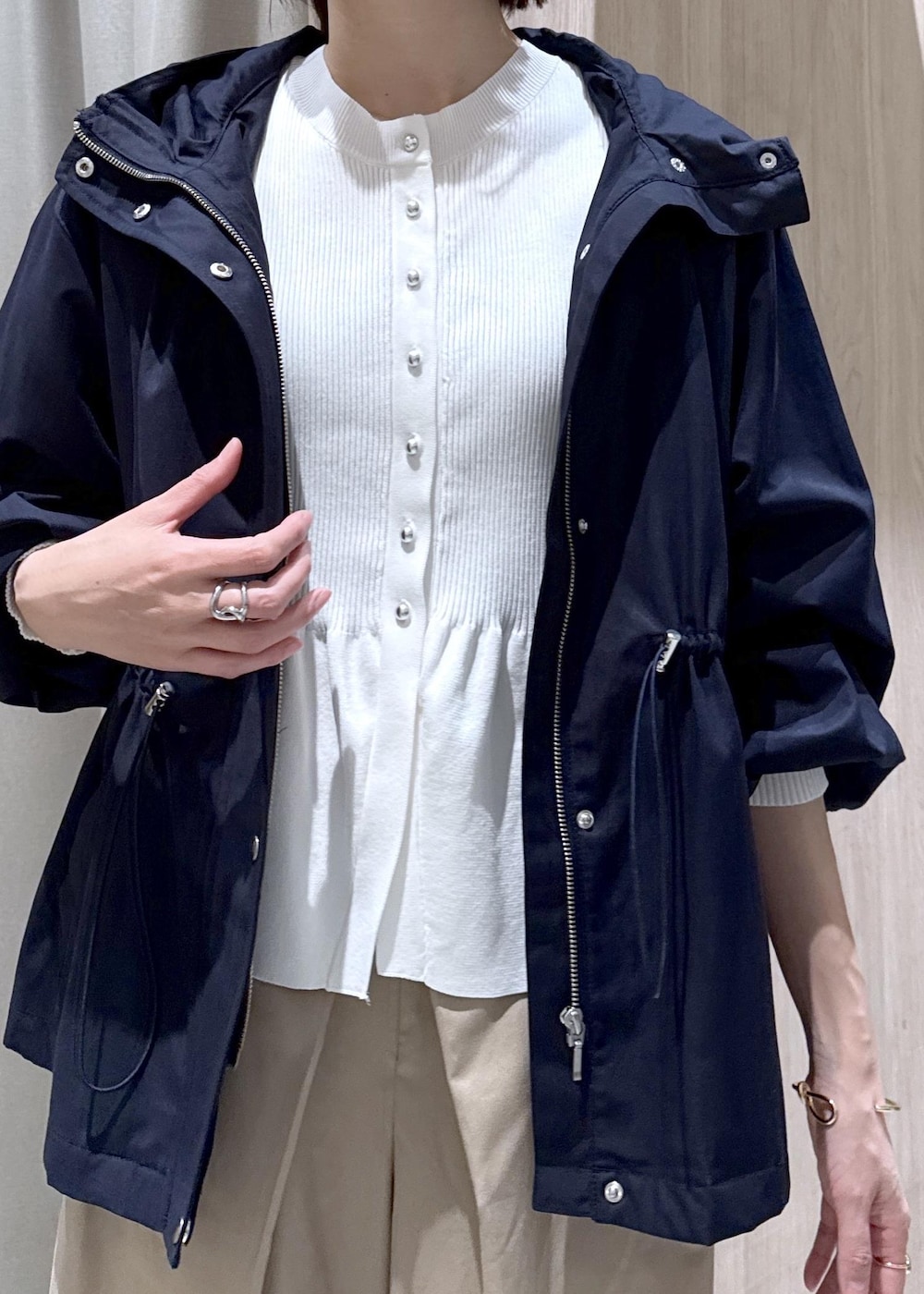 ホワイト系のカーディガン/ボレロ、ホワイト系のトートバッグ、ブルー系のナイロンジャケットを着用したレディースの春コーディネートの6枚目の写真