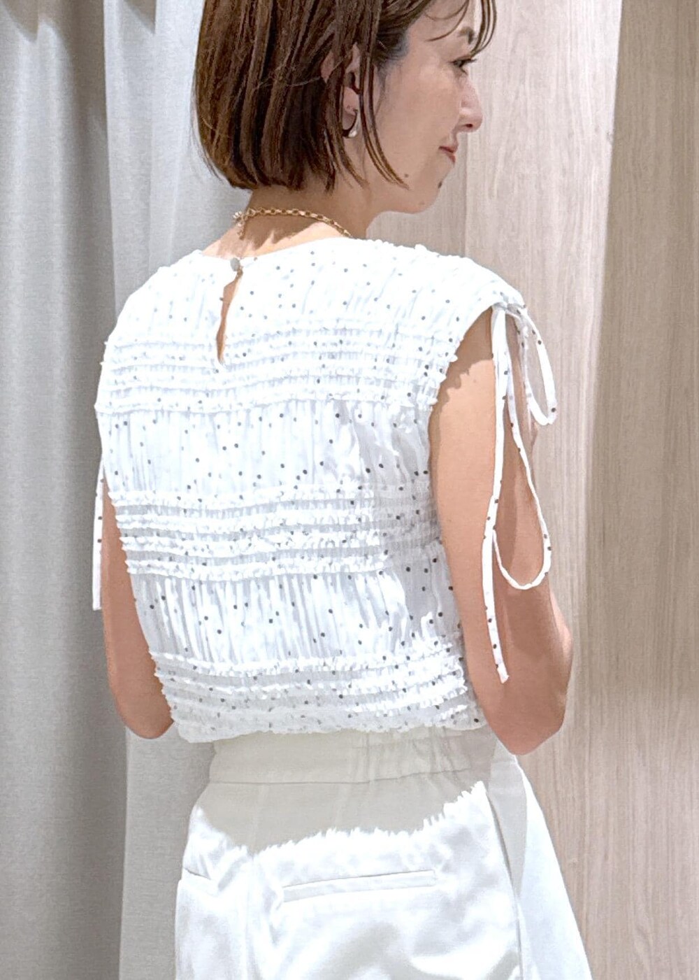 ブルー系のハンドバッグ、ブラック系のパンプス、ホワイト系のシャツ/ブラウスを着用したレディースの夏コーディネートの9枚目の写真
