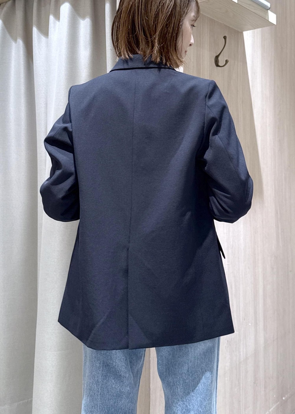 ホワイト系のニット/セーター、ブルー系のテーラードジャケット、ブルー系のデニムパンツを着用したレディースの冬コーディネートの5枚目の写真