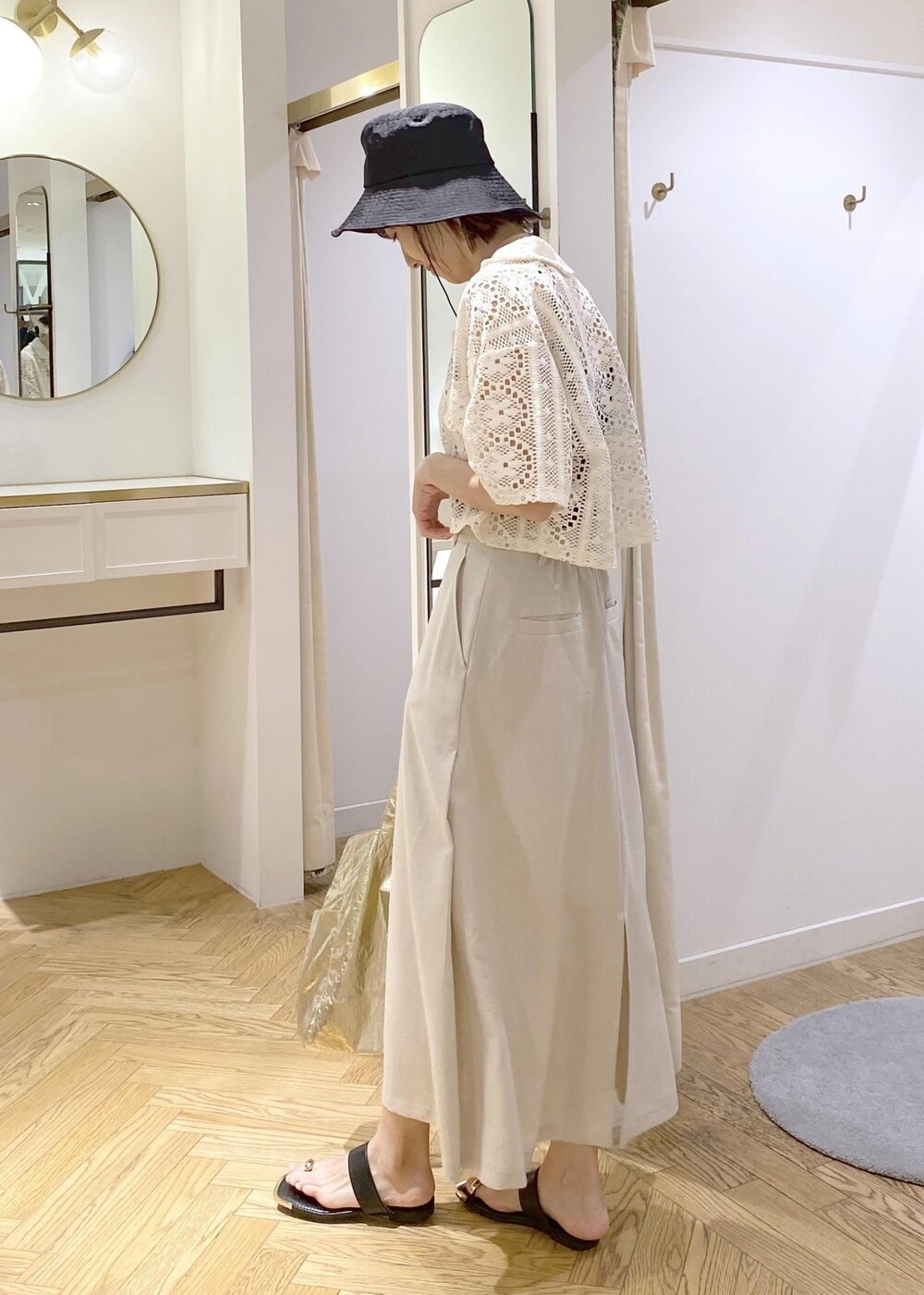 ブラック系のキャミソール、ブラック系のサンダル、ゴールド系のトートバッグを着用したレディースの春コーディネートの2枚目の写真