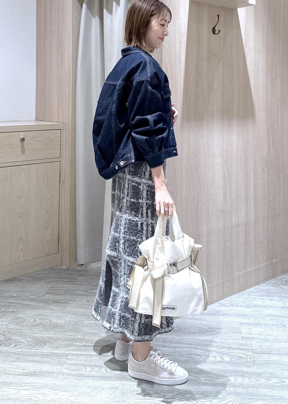 グレー系のスニーカー、グレー系のスカート、ブラウン系のニット/セーターを着用したレディースの冬コーディネートの3枚目の写真