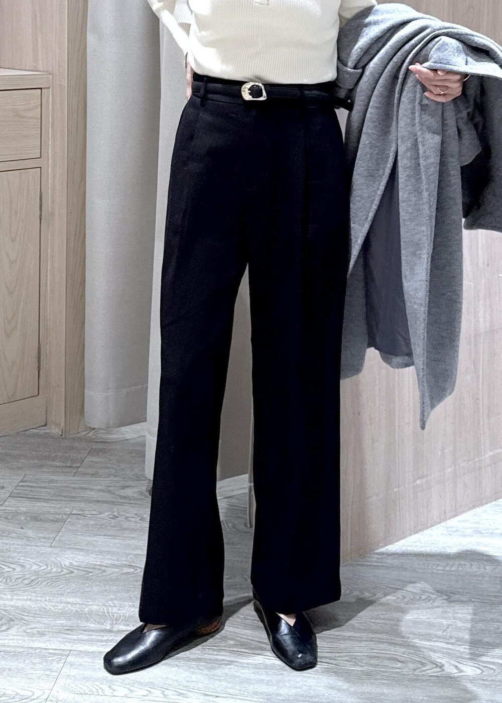 ホワイト系のニット/セーター、グレー系のその他アウター、ブラック系のスラックスを着用したレディースの冬コーディネートの9枚目の写真