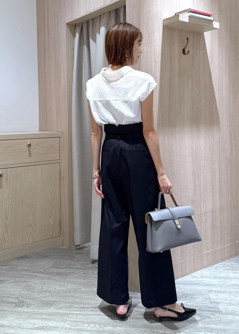 グレー系のハンドバッグ、ブラック系のパンプス、ベージュ系のキャミソールを着用したレディースの夏コーディネートの4枚目の写真