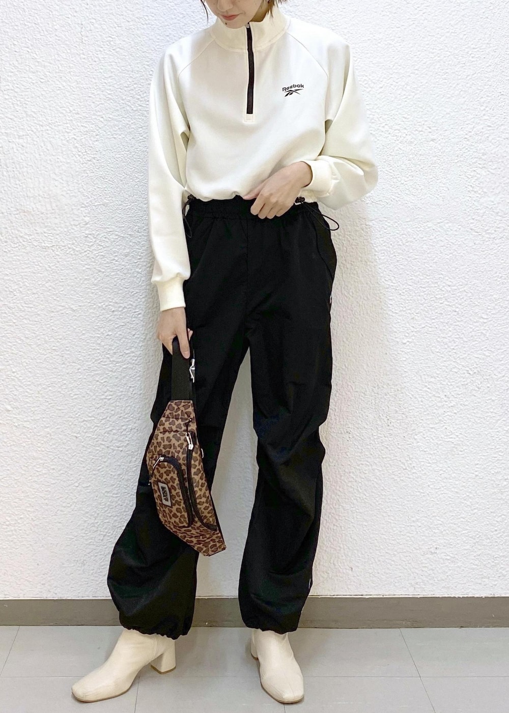 ブラウン系のボディバッグ/ウエストポーチ、ブラック系のその他パンツ、ホワイト系のその他トップスを着用したレディースの冬コーディネートの4枚目の写真