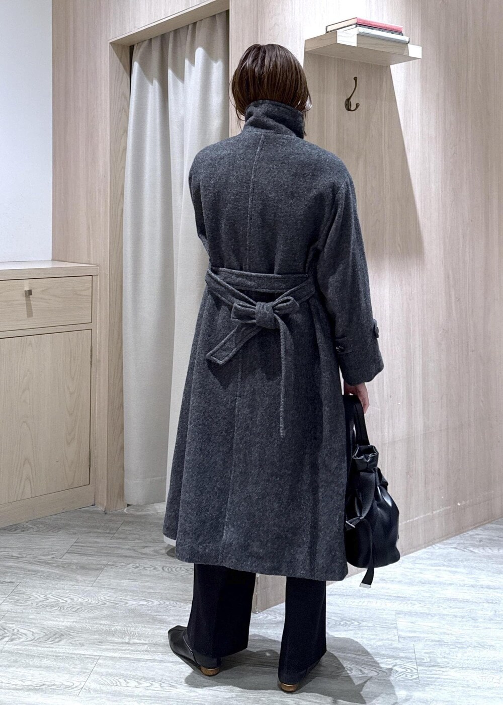 ブラック系のスラックス、グレー系のその他アウター、ブルー系のシャツ/ブラウスを着用したレディースの冬コーディネートの7枚目の写真