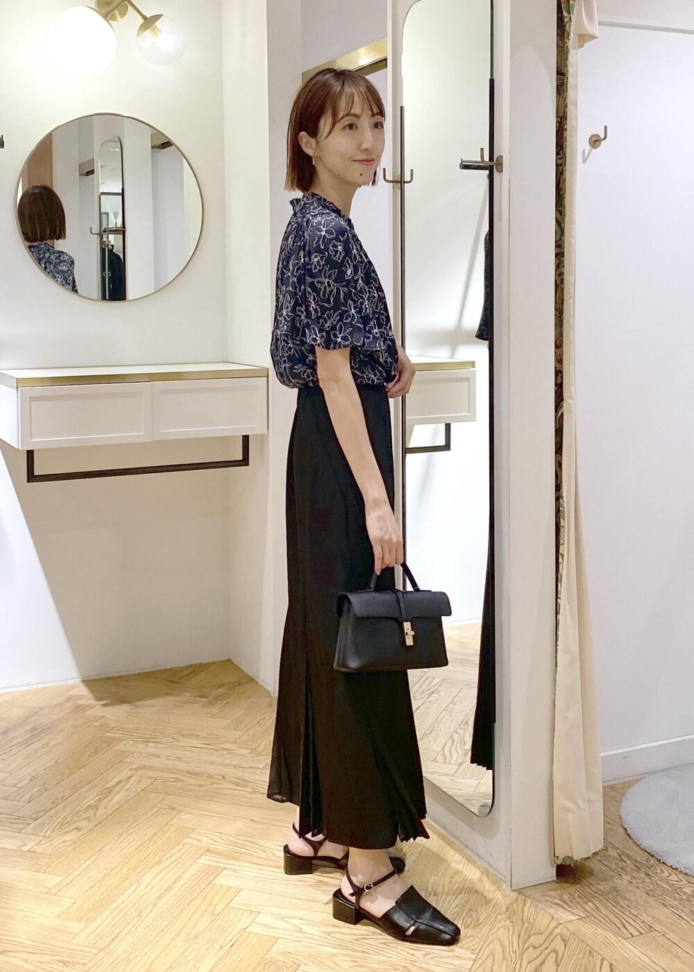 ブラック系のキャミソール、ブラック系のサンダル、ブラック系のスカートを着用したレディースの春コーディネートの3枚目の写真