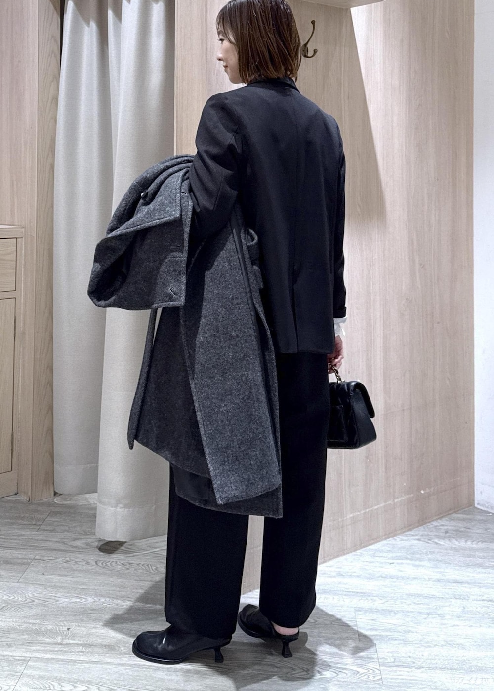 ブラック系のスラックス、ブラック系のテーラードジャケット、グレー系のその他アウターを着用したレディースの冬コーディネートの2枚目の写真