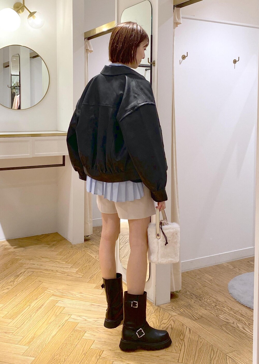 ブルー系のシャツ/ブラウス、ブラック系のブーツ、ブラック系のブルゾンを着用したレディースの秋コーディネートの2枚目の写真