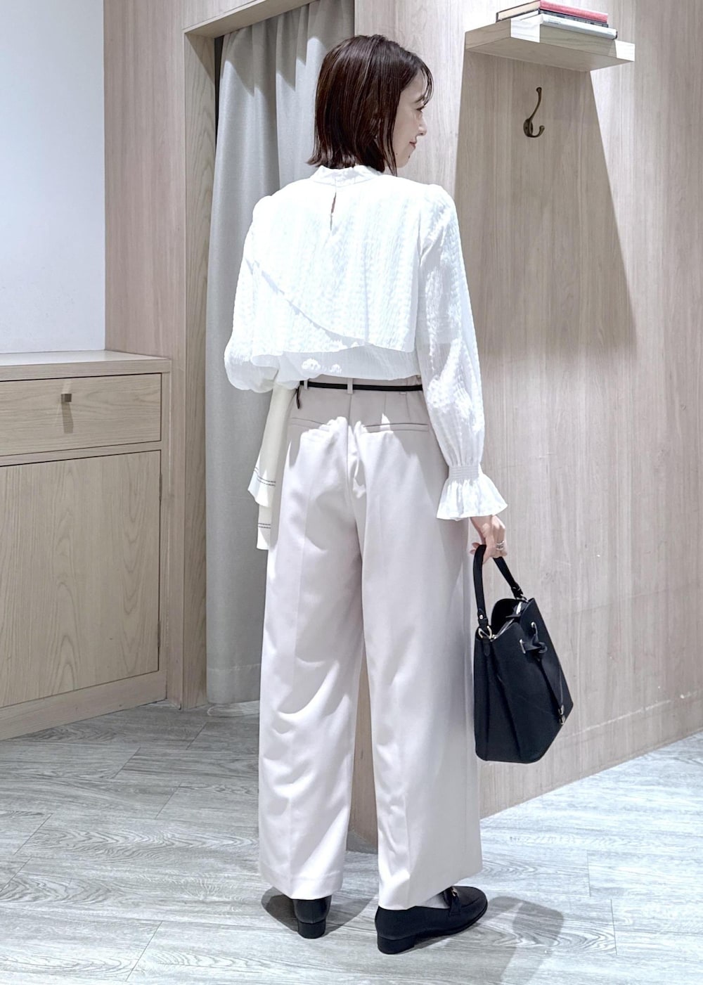 ブラック系のショルダーバッグ、ホワイト系のシャツ/ブラウス、ベージュ系のその他パンツを着用したレディースの冬コーディネートの10枚目の写真