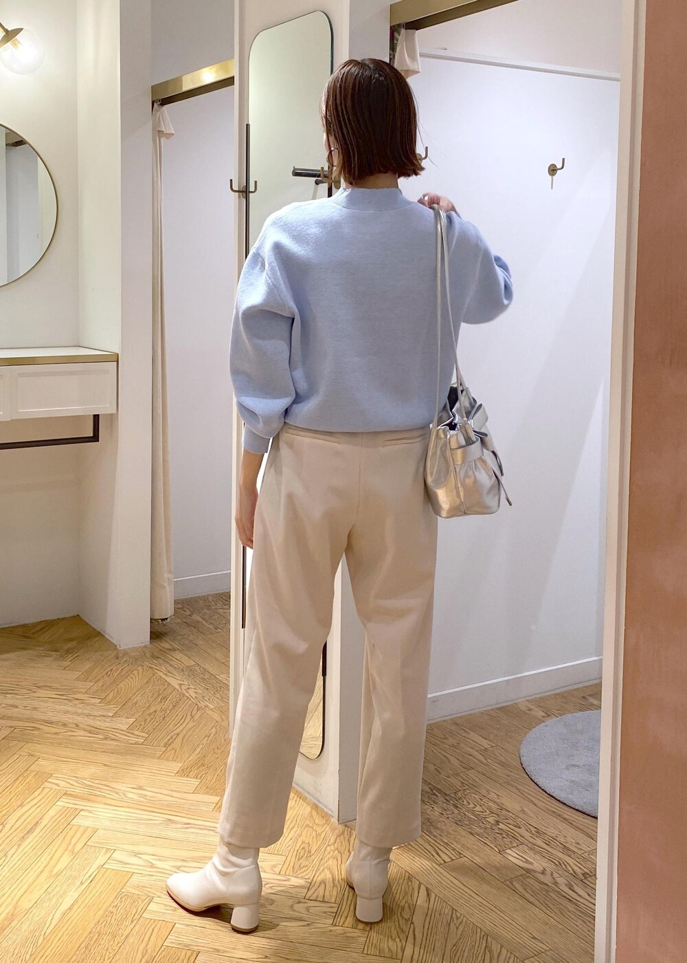 ホワイト系のブーツ、ブルー系のニット/セーター、ベージュ系のその他パンツを着用したレディースの冬コーディネートの4枚目の写真