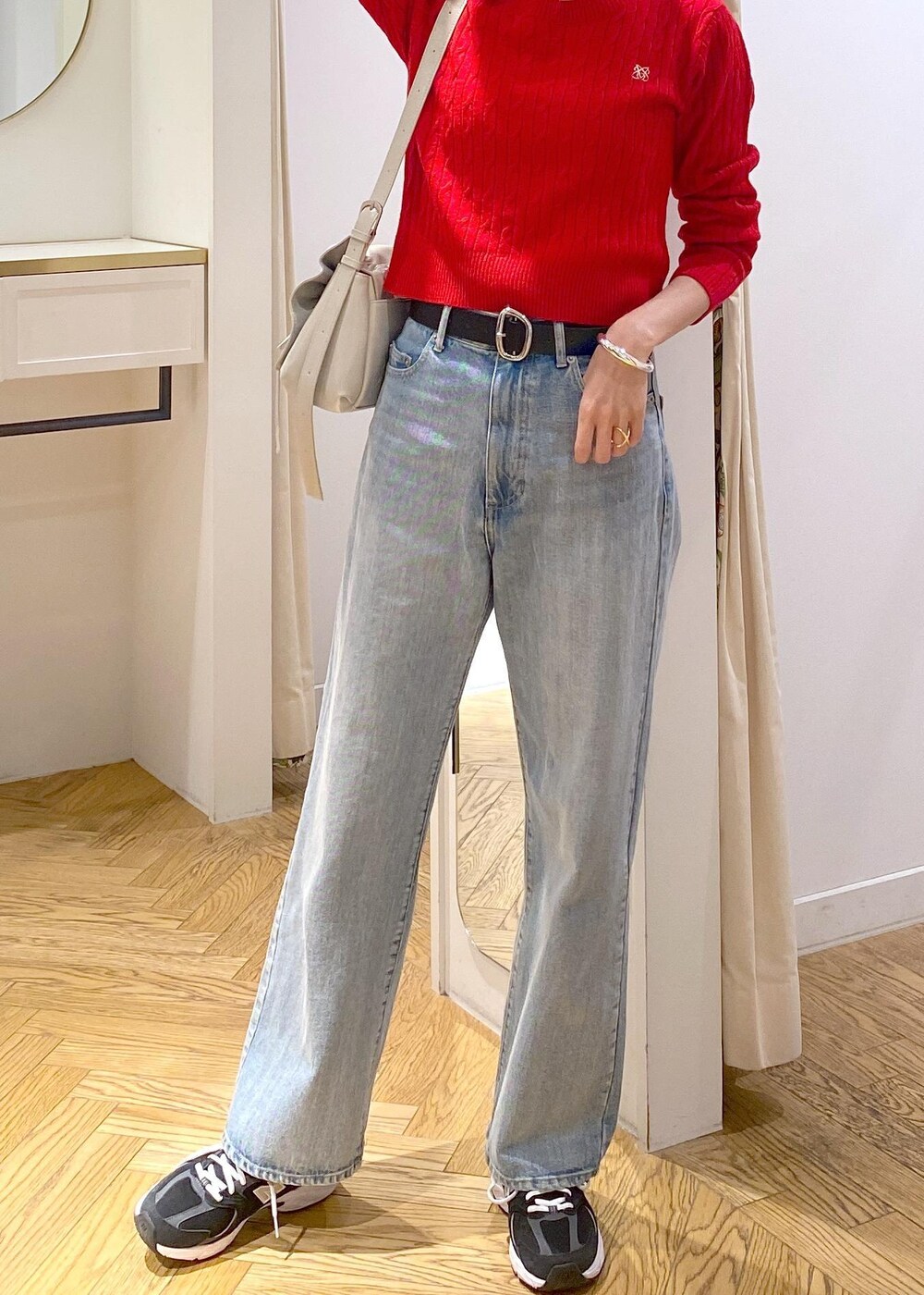 レッド系のニット/セーター、ブルー系のデニムパンツ、ブラック系のベルトを着用したレディースの冬コーディネートの6枚目の写真