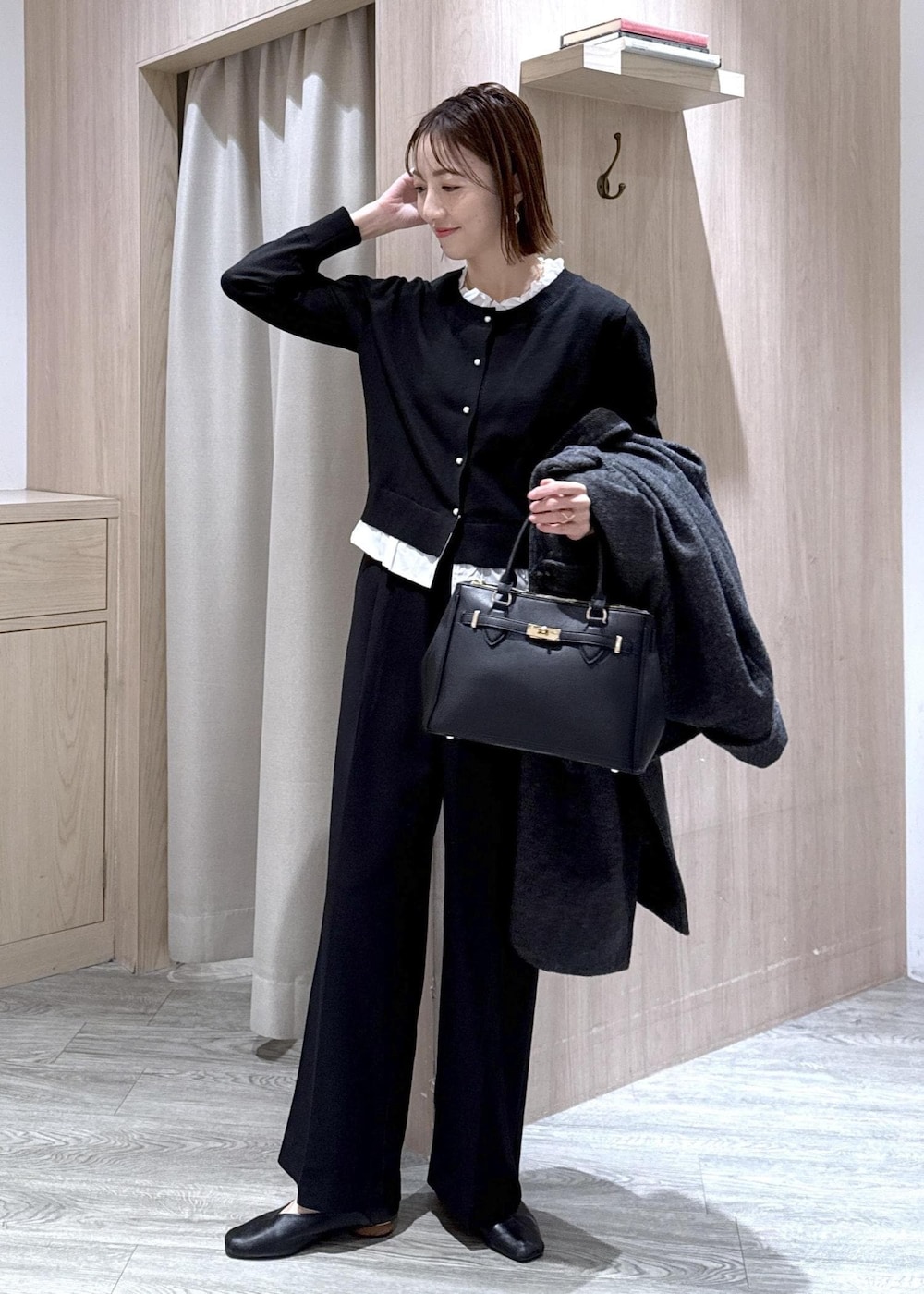 ブラック系のショルダーバッグ、ブラック系のスラックス、グレー系のその他アウターを着用したレディースの冬コーディネートの2枚目の写真