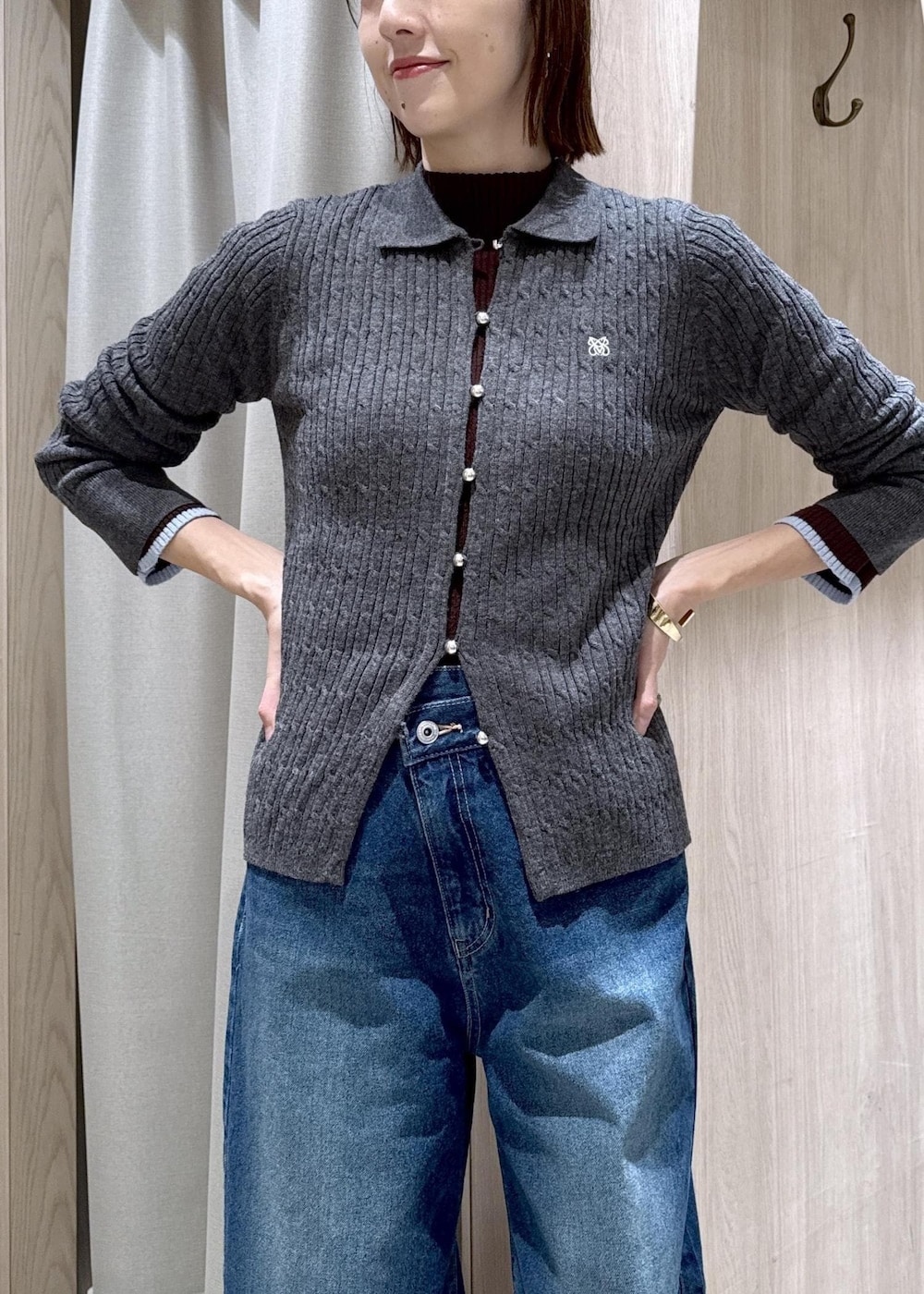 ブラック系のショルダーバッグ、ブルー系のデニムパンツ、グレー系のブルゾンを着用したレディースの冬コーディネートの6枚目の写真