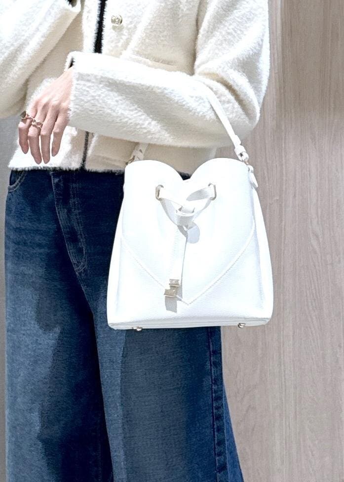 ホワイト系のショルダーバッグ、ブルー系のデニムパンツ、ブラック系のニット/セーターを着用したレディースの冬コーディネートの8枚目の写真