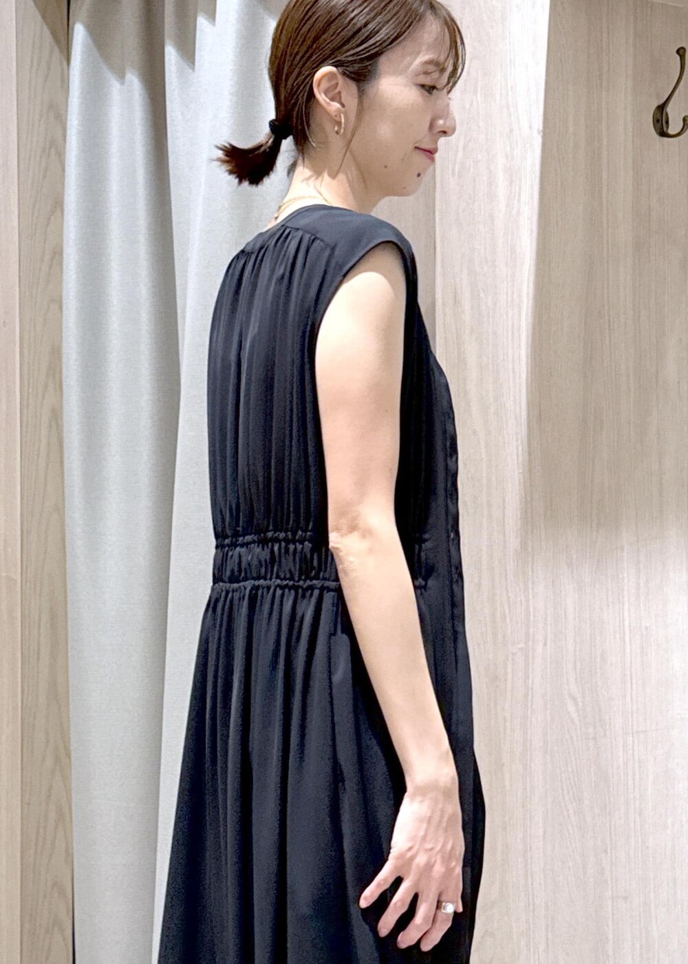 ホワイト系のタンクトップ、ブラック系のスラックス、シルバー系のハンドバッグを着用したレディースの春コーディネートの7枚目の写真