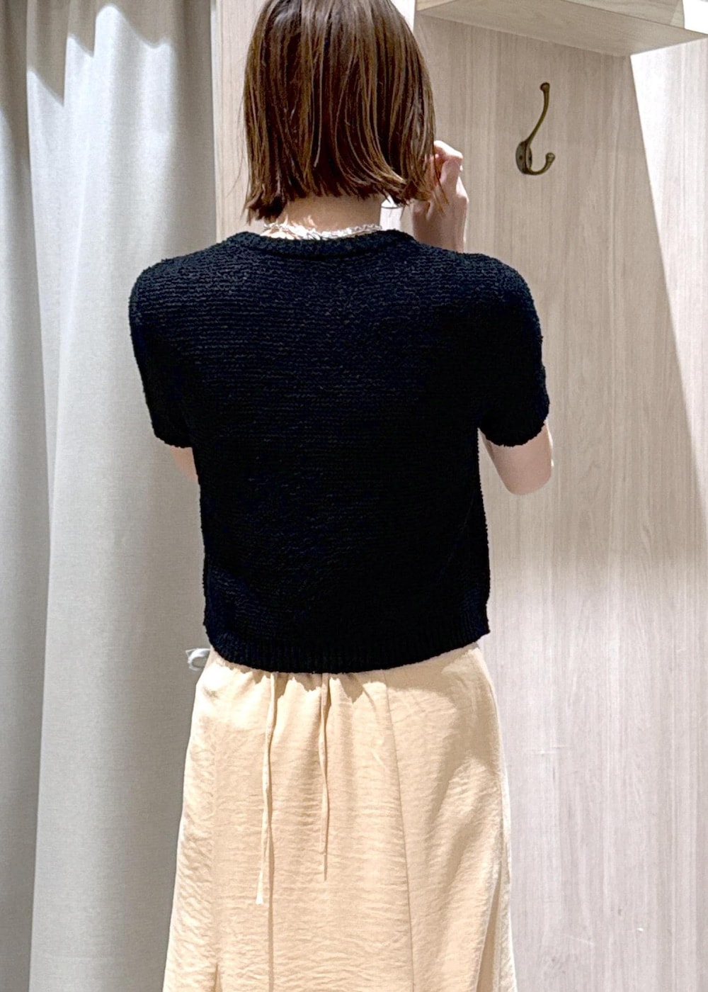 ブラック系のパンプス、オレンジ系のスカート、ブラック系のハンドバッグを着用したレディースの春コーディネートの9枚目の写真