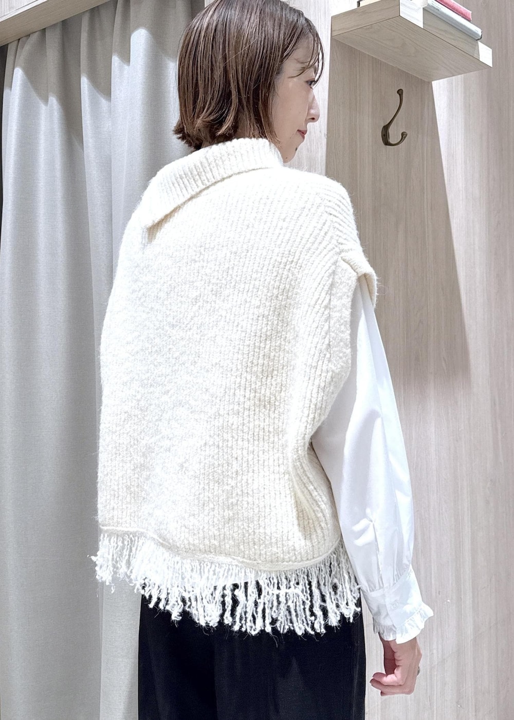 ブラック系のスラックス、ホワイト系のベスト、ホワイト系のシャツ/ブラウスを着用したレディースの秋コーディネートの4枚目の写真