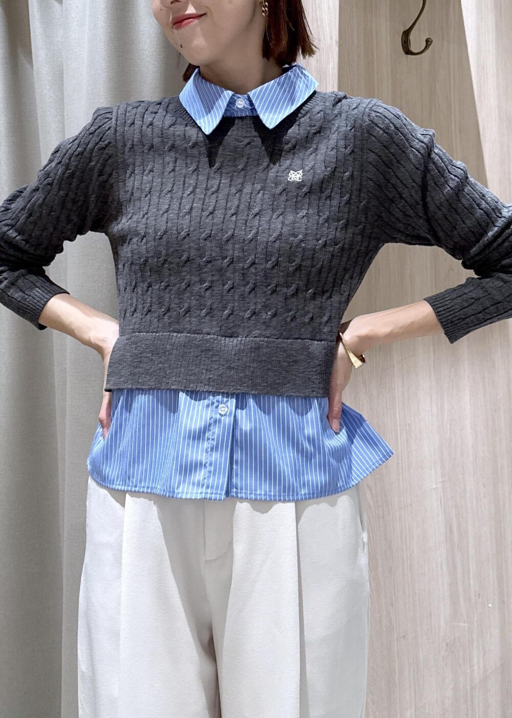 ブラック系のショルダーバッグ、グレー系のその他アウター、ホワイト系のスラックスを着用したレディースの冬コーディネートの8枚目の写真