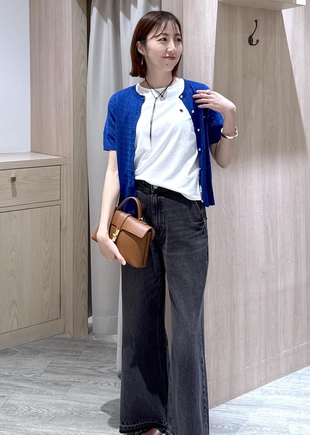 イエロー系のショルダーバッグ、ブラック系のデニムパンツ、ホワイト系のTシャツ/カットソーを着用したレディースの春コーディネートの4枚目の写真