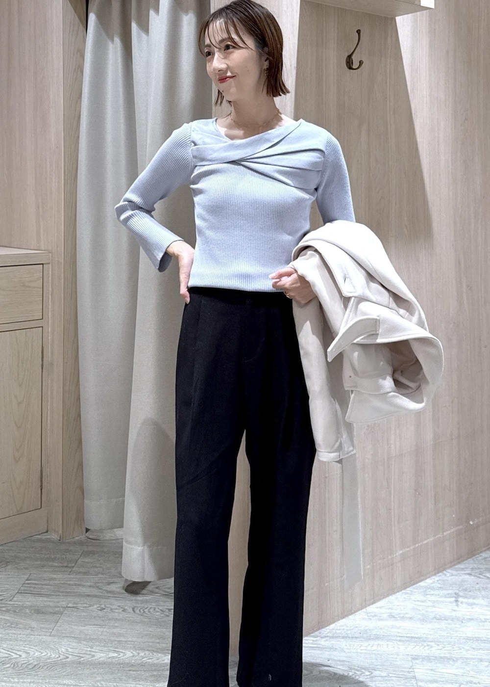 ブラック系のスラックス、ブラック系のショルダーバッグ、ブルー系のニット/セーターを着用したレディースの秋コーディネートの9枚目の写真